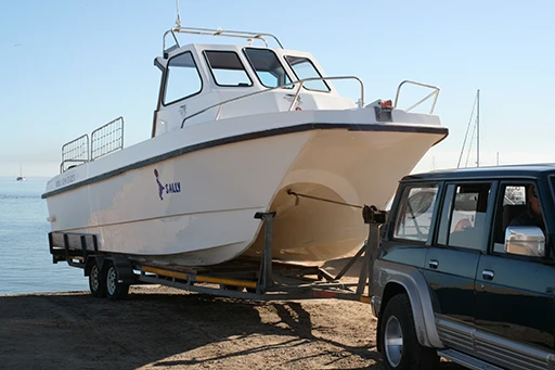 Truck towing a boat on a trailer down a boat ramp